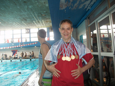 Pineda sonríe al lado de la pileta, con las medallas ganadas en el torneo.