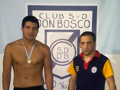 Norberto López celebra con sus medallas, junto a su entrenador.