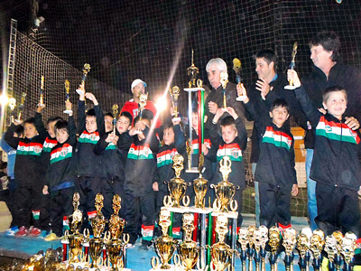 Los ganadores levantando sus trofeos, junto a los organizadores del torneo.