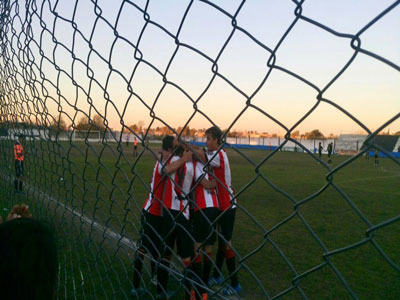 Destrás del alambrado, los jugadores del Juventud festejan uno de los goles.