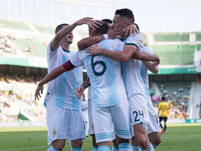 Ocampos se abraza con sus compañeros en el gol convertido ante Ecuador.