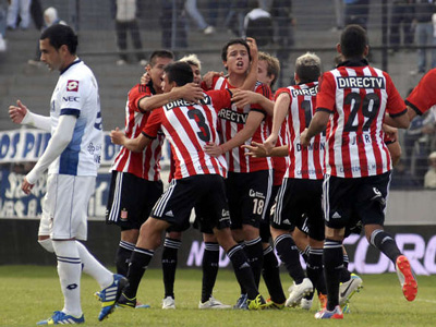 Estudiantes festeja uno de sus goles, ante la desazón de Telechea y todo Quilmes.