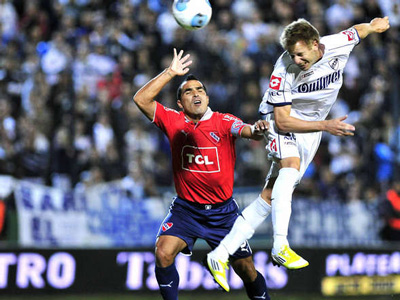 Menéndez busca la pelota ante la marca de Morel Rodríguez. Partido muy friccionado.